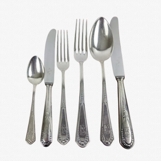 Exquisite 70-piece cutlery set for 12 guests, featuring elegant E.S. monograms.